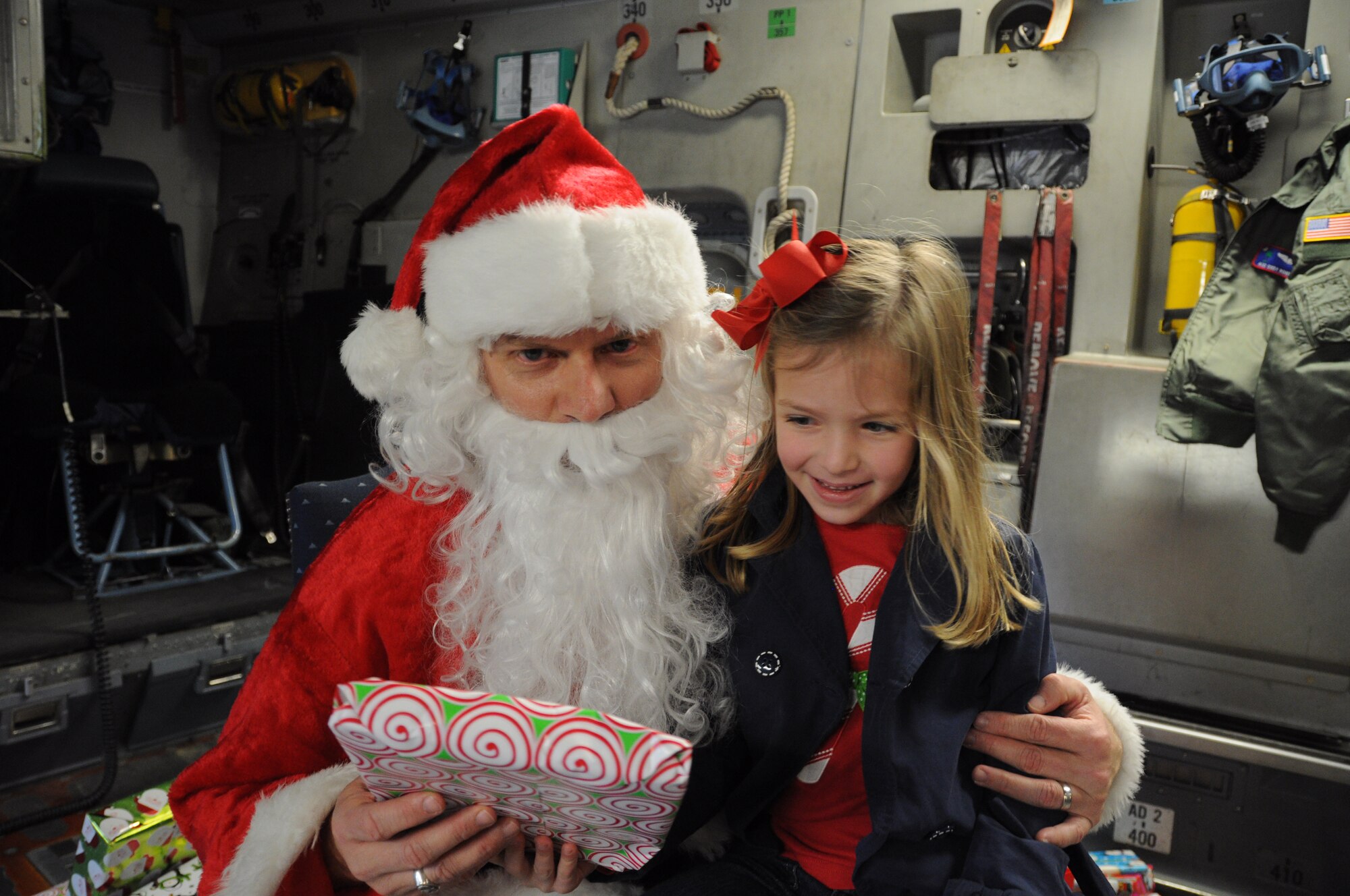 Santa Claus delivers a present to a happy little girl Dec. 10, 2011 at Joint Base Charleston, S.C. Even though Christmas is right around the corner, Santa took time out of his busy schedule to spread lots of Joy to friends and families of the 315th Airlift Wing. (U.S. Air Force photo/ Staff Sgt. Shane Ellis)