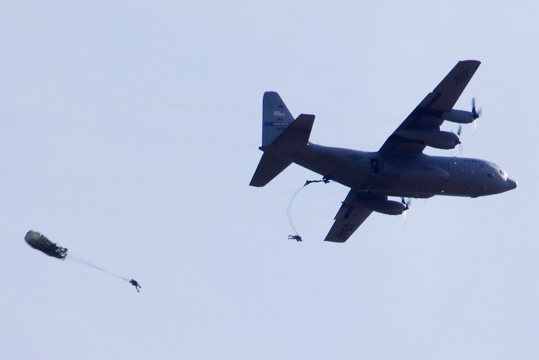 Paratroopers jump from the door of a C-130 Hercules aircraft in support of the 14th Annual Randy Oler Memorial Operation Toy Drop over Fort Bragg, N.C. Dec. 10, 2011.