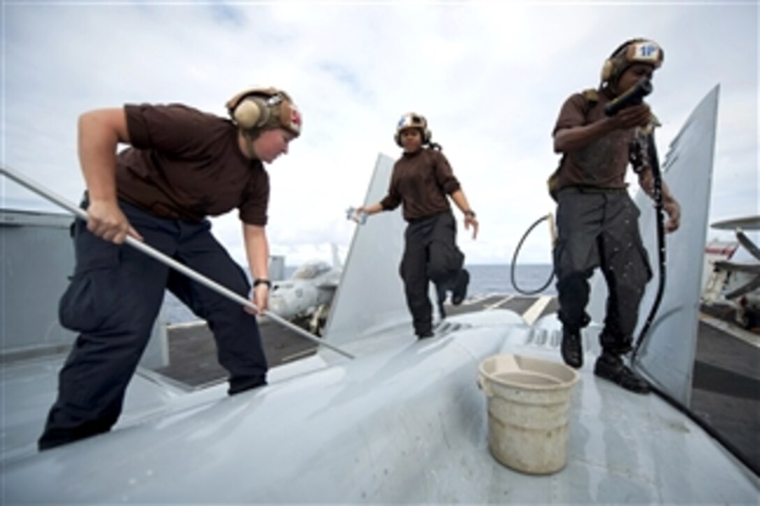 U.S. Navy Seaman Katie Griffith, Petty Officer 3rd Class Veronica Calhoun and Seaman Reginald Dean wash down an F/A-18F Super Hornet on the flight deck of the aircraft carrier USS Carl Vinson (CVN 76) underway in the Pacific Ocean on Dec. 6, 2011.  Griffith is an aviation machinist's mate airman, Calhoun is an aviation electronics technician and Dean is an aviation structural mechanic airman assigned to Strike Fighter Squadron 22.  