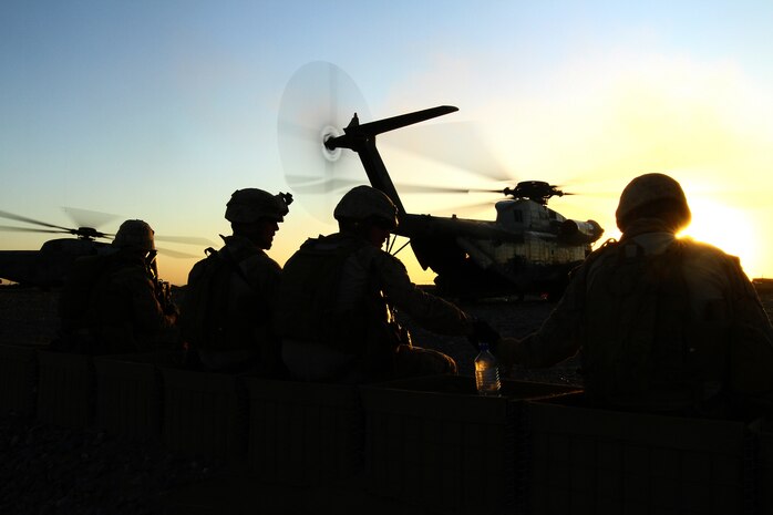 U.S. Marines with the air interdiction force composed of 1st Battalion, 25th Marine Regiment, and 2nd Bn., 11th Marines, pause for a break as a CH-53 Sea Stallion refuels during an Afghan Border Police led clearing operation here, Dec. 7. The AIF circles high in sky above, searching for suspicious vehicles or personnel, and plays a unique role in counter-insurgency operations in southern Helmand.