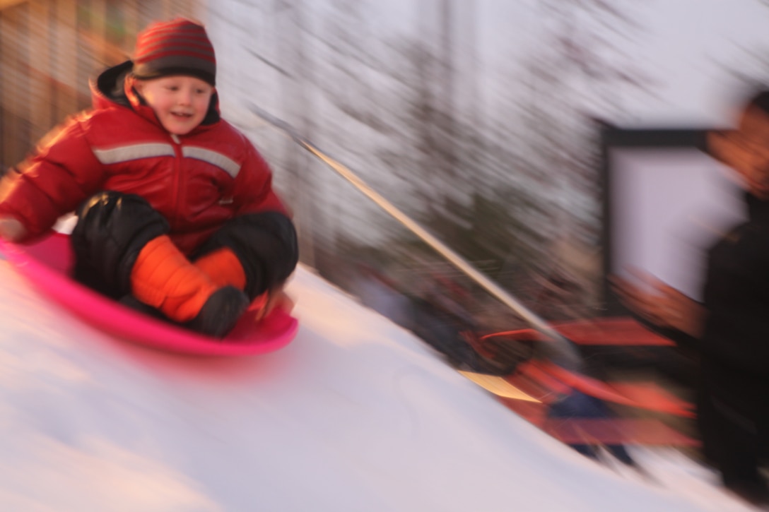 An attendant of the Atlantic Marine Corps Communities Home for the Holidays event sleds down the snow packed slide at the AMCC Bicentennial Community Center aboard Marine Corps Base Camp Lejeune, recently.