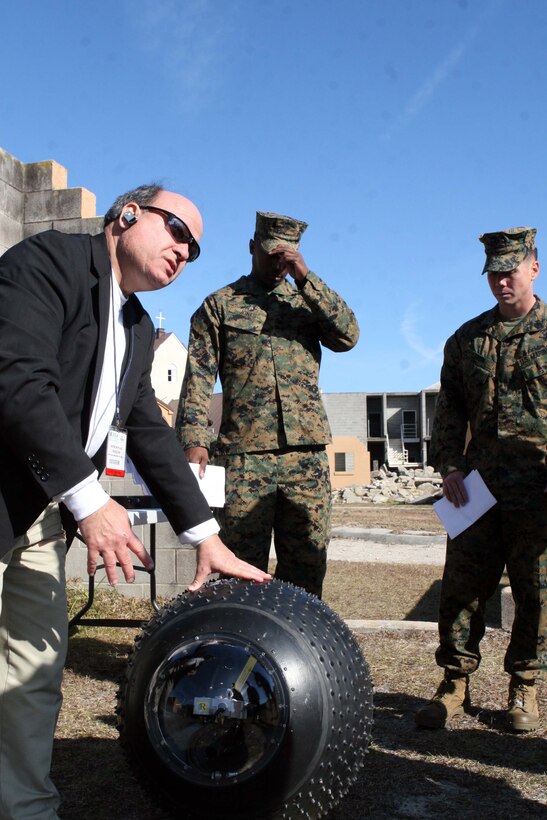 Various Marines from Marine Corps Base Camp Lejeune, N.C., take a look at a guard bot displayed by Peter Muhlrad the president of American Unmanned Systems. Muhlrad brought his product to be displayed in hopes that the Marines would see a use for it in their arsenal and give constructive feedback.
