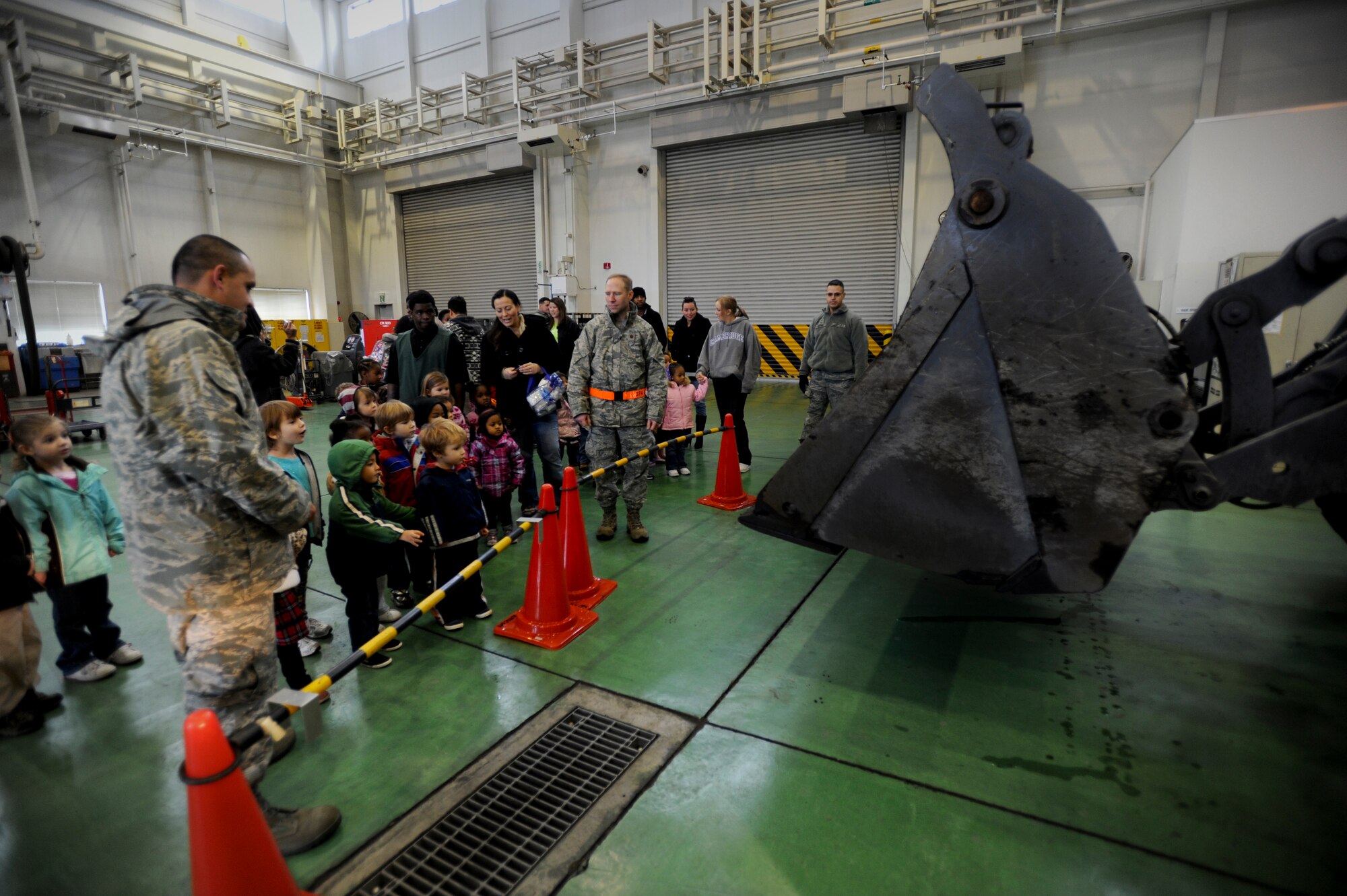 YOKOTA AIR BASE, Japan -- Children from the Kibo Child Development Center on Yokota Air Base, Japan, watch as the bucket on a front-end loader is raised Dec. 2, 2011. The children visited the vehicle operations center and learned about the various vehicles they see on base from the Airmen who operate them. (U.S. Air Force photo/Staff Sgt. Stacy Moless)    