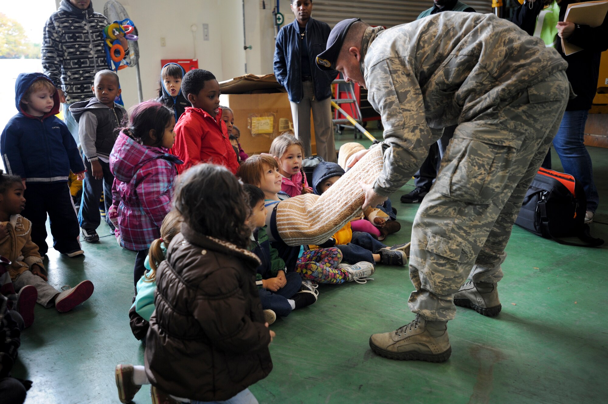 YOKOTA AIR BASE, Japan -- Staff Sgt. Charles Salton, 374th Security Forces Squadron dog handler, shows children from the Kibo child development center on Yokota Air Base, Japan, an intermediate bite sleeve Dec. 2, 2011. The demonstration was part of a field trip the children took to the vehicle operations center where they were able to see different vehicles from around base. (U.S. Air Force photo/Staff Sgt. Stacy Moless)    