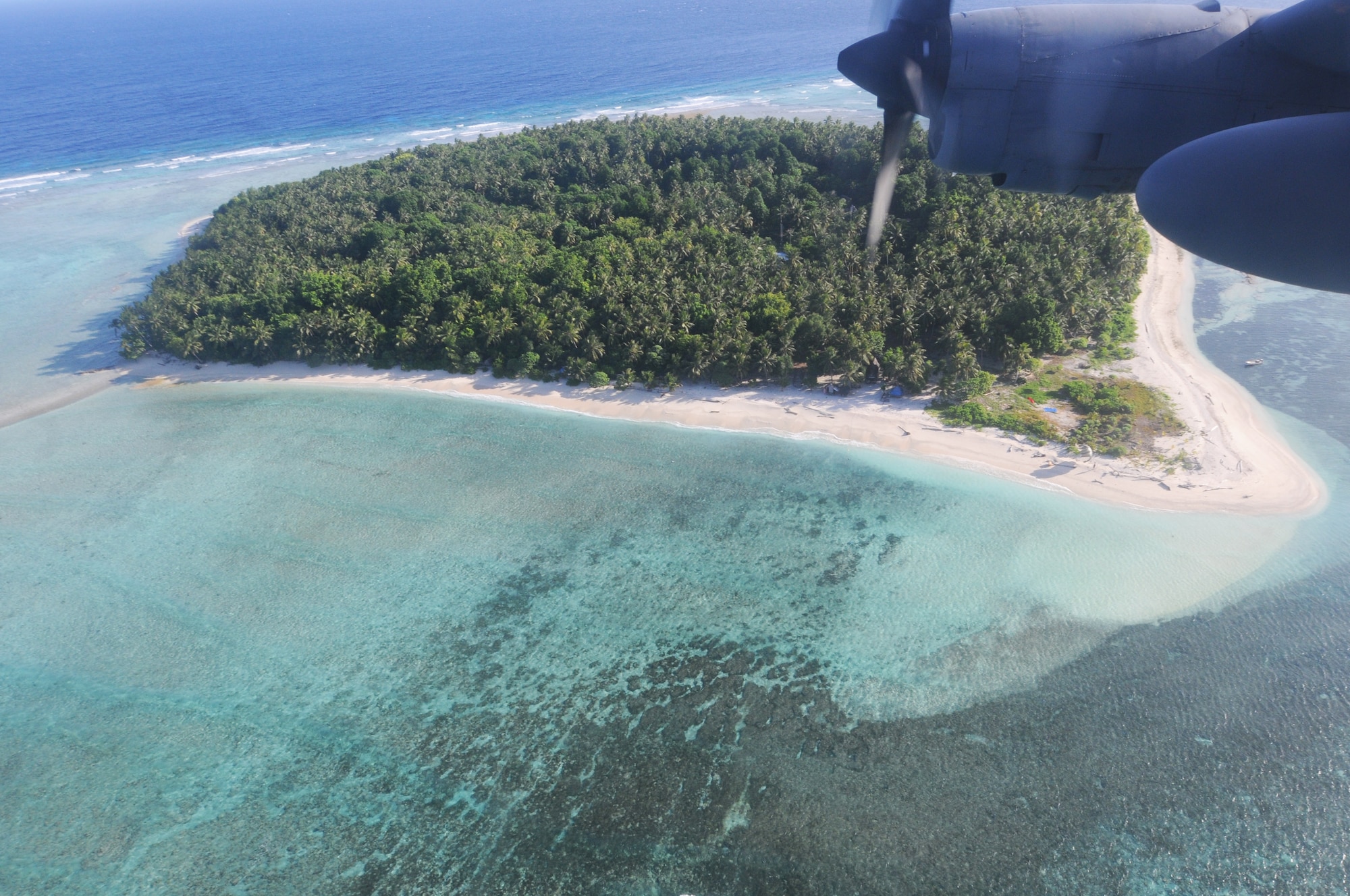 ANDERSEN AIR FORCE BASE, Guam - A C-130 completes a fly-by ensuring safe arrival of the Operation Christmas Drop care package to Ngulu Island of the Micronesian Islands, Dec. 12. The pallet was a box full of goodies for the islanders containing school supplies, toys, medical supplies and common day items. (U.S. Air Force photo/Senior Airman Carlin Leslie)