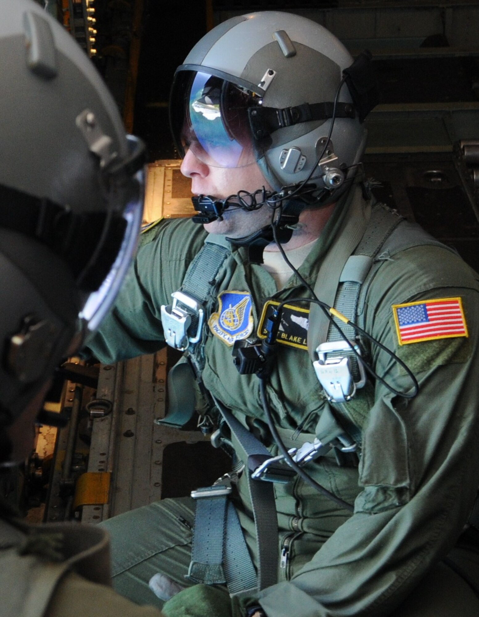 ANDERSEN AIR FORCE BASE, Guam - Staff Sgt. Blake Landry, 374th Airlift Wing loadmaster, gazes out of the door of a C-130 aircraft checking to make sure the pallet that was just pushed reached the island safely, Dec. 12. OCD will deliver care packages to more than 50 islands within Micronesian States during the next two weeks. (U.S. Air Force photo/Senior Airman Carlin Leslie)