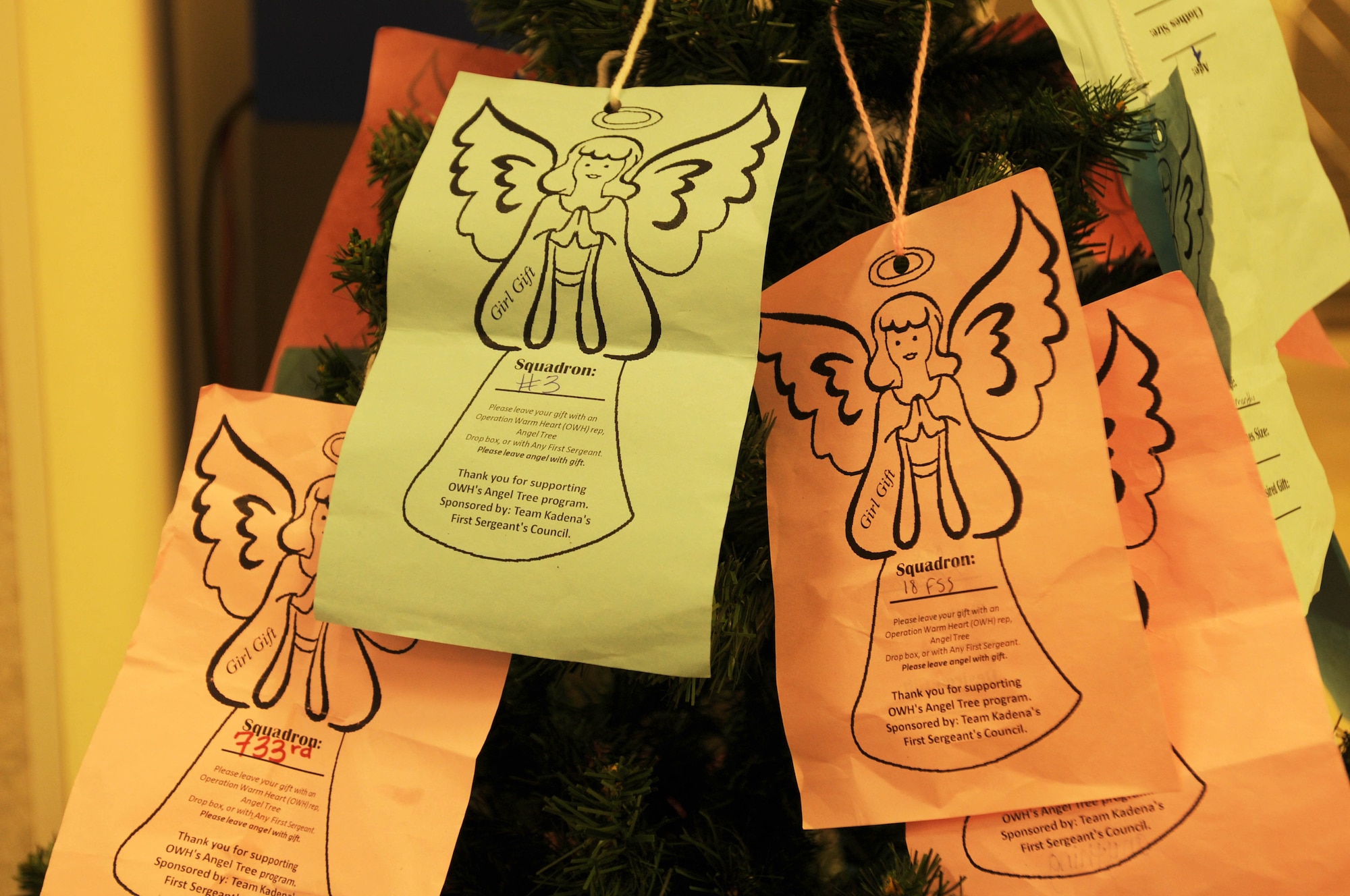 Information on Team Kadena 'angels' hangs on the Kadena first sergeants' Angel Tree in the Exchange food court on Kadena Air Base, Japan, Dec. 13, 2011. The angels allow Team Kadena members to support the children of families that need a little help putting gifts under the tree this holiday season, as identified by Team Kadena first sergeants. (U.S. Air Force photo by Tech. Sgt. Amanda Savannah/Released)