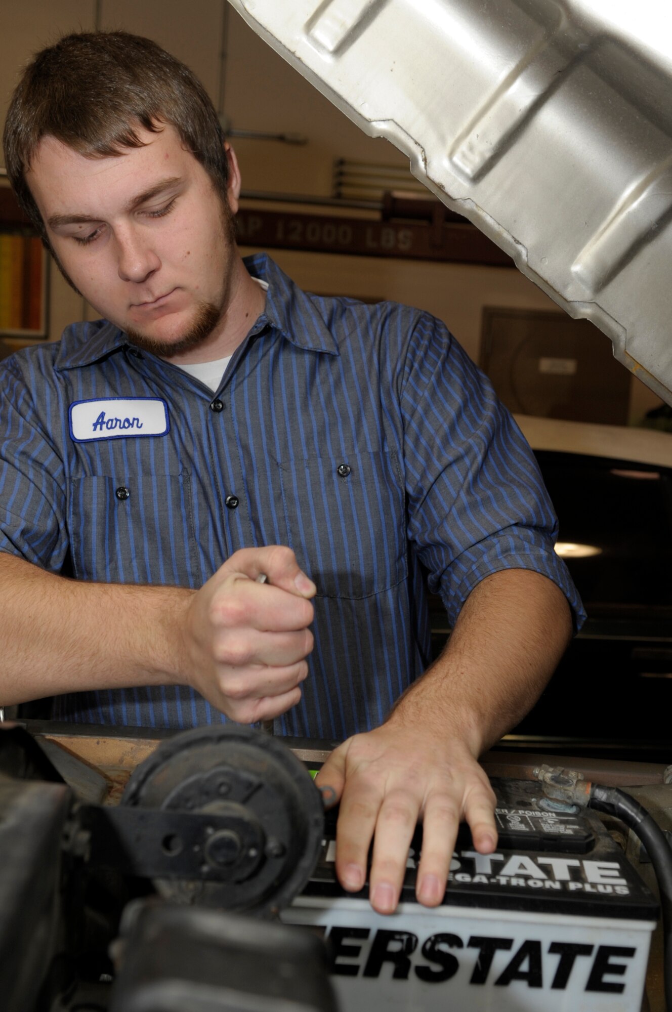 VANDENBERG AIR FORCE BASE, Calif. -- Aaron Moreheart, an automotive specialist, tightens a battery connection on a pick-up truck at the auto hobby shop here Friday, Dec. 9, 2011. The auto hobby shop is open to customers with base access offering a variety of services and a knowledgeable staff to help with automotive projects. 
(U.S. Air Force photo/Jerry E. Clemens Jr.)