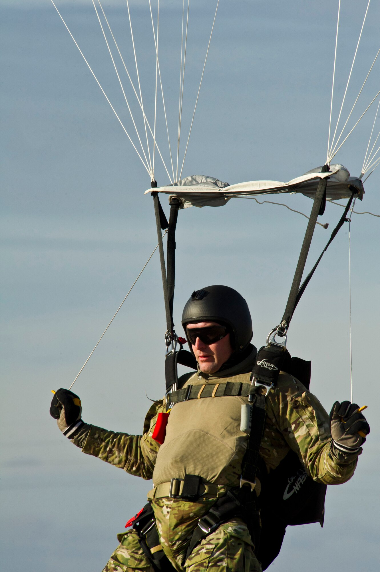 Tech. Sgt. Douglas Dinger, SERE specialist, prepares to land from a free-fall parachuting jump above Fairchild Dec. 5. Flaring the parachute to avoid hitting the ground too fast is the proper technique to use when preparing to land safely to the ground. (U.S. Air Force photo/Airman 1st Class Taylor Curry)