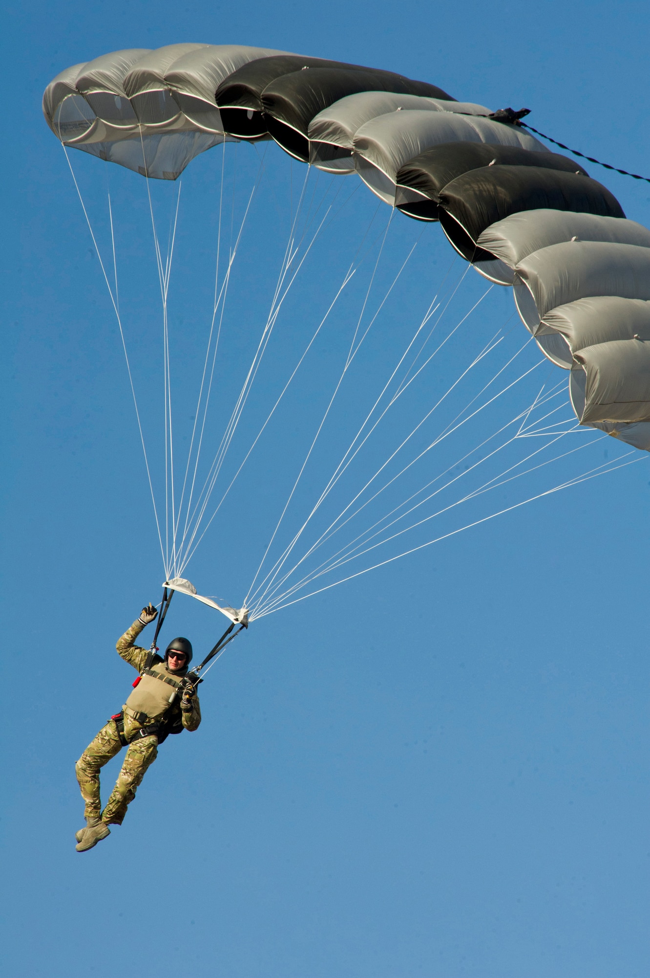 Tech. Sgt. Douglas Dinger, SERE specialist, prepares to land from a free-fall parachuting jump above Fairchild Dec. 5. Flaring the parachute to avoid hitting the ground too fast is the proper technique to use when preparing to land safely to the ground. (U.S. Air Force photo/Airman 1st Class Taylor Curry)
