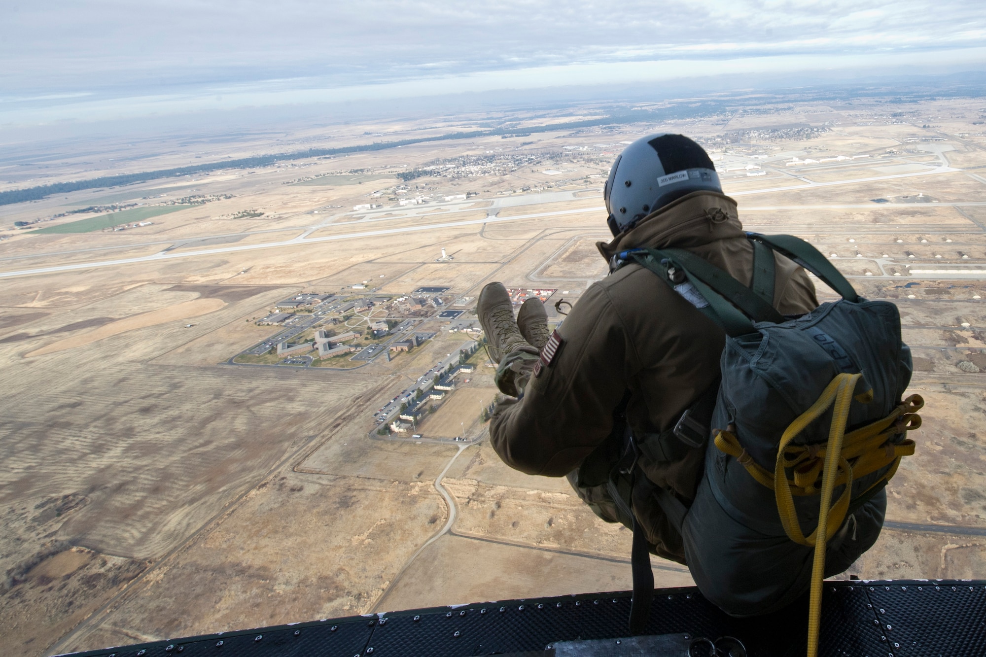Staff Sgt. Sean Marlow, SERE specialist, performs a static line parachute jump from a UH-1 Huey helicopter above Fairchild Dec. 5. These jumps are practiced weekly by students and instructors to ensure students are receiving the proper training for any situation. (U.S. Air Force photo/Airman 1st Class Taylor Curry)