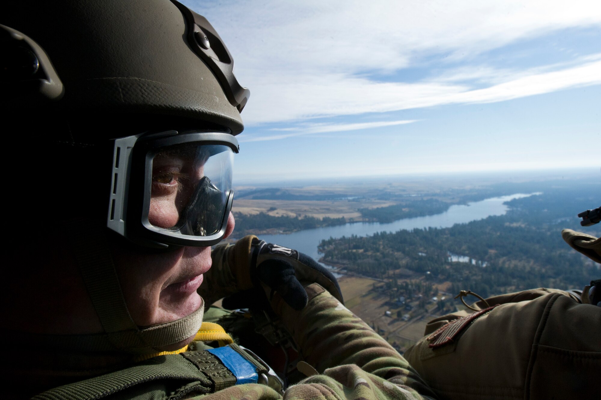 Tech. Sgt. Justin McCaffrey, SERE specialist, waits for the UH-1 Huey helicopter to reach appropriate altitude to perform a static line parachuting jump above Fairchild Dec. 5. “A static line jump is normally executed at 1,250 feet in the air, and a free-fall jump is normally executed at 12,000 feet,” said Tech. Sgt. Douglas Dinger, SERE specialist. (U.S. Air Force photo/Airman 1st Class Taylor Curry)
