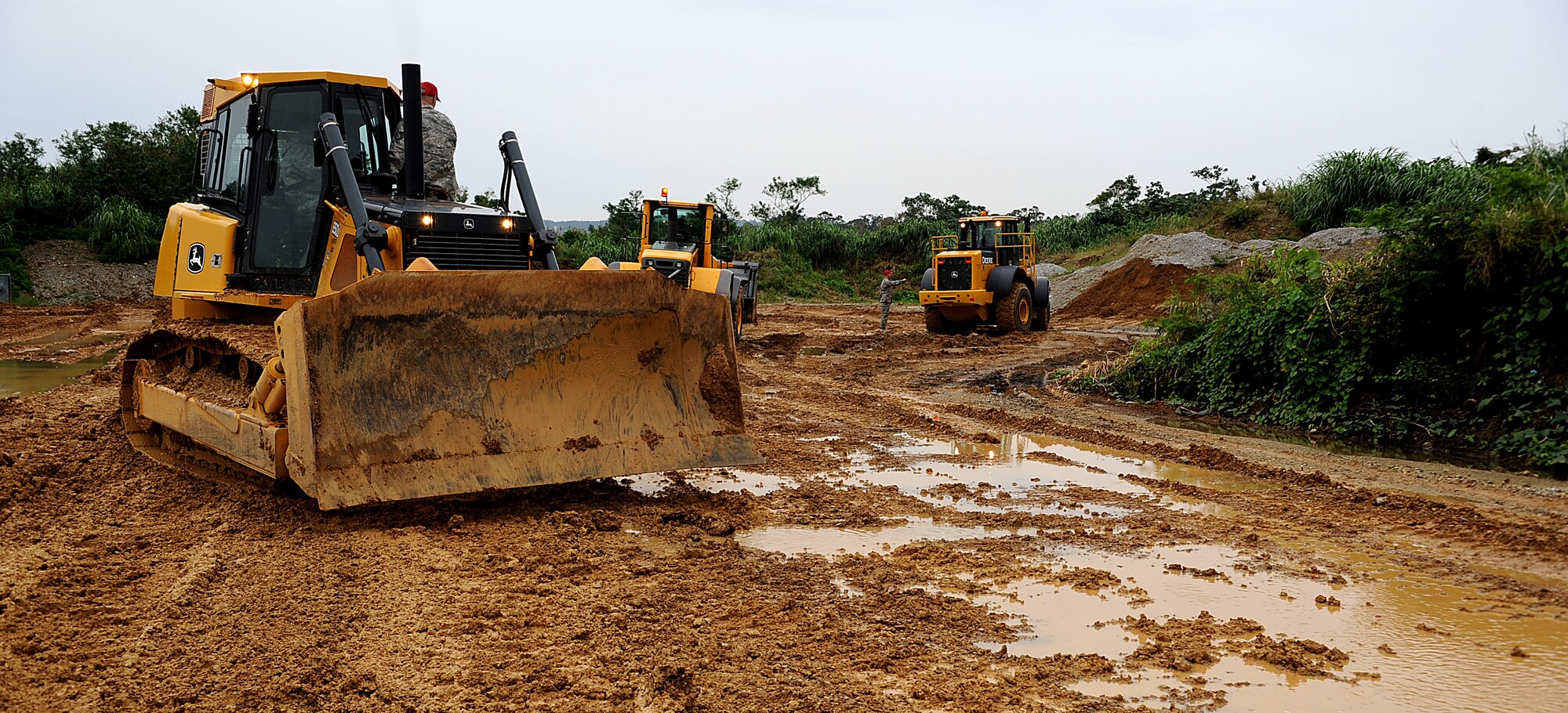 Airmen from the 18th Wing use bulldozers to practice leveling the berms and dikes area while touring Detachment 1, 554th RED HORSE Squadron facilities Dec. 13, 2011 on Kadena Air Base, Japan. During the tour members learned how to search for hazardous materials, operate civil engineer equipment and rappel from buildings during a fire scenario. (U.S. Air Force photo by Staff Sgt. Christopher Hummel/Released)
