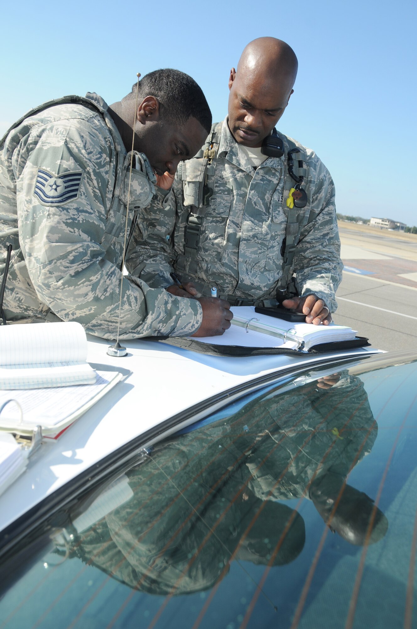 During an anti-hijacking exercise on the flightline at Keesler Air Force Base, Miss., Dec. 12, 2011, Tech. Sgts. Phillip Bell and Teddy Poole, 81st Security Forces Squadron, conduct a security check to secure units.  (U.S. Air Force photo by Kemberly Groue)