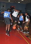 Caught between two 717th Mi Bn players, 802nd FSS guard Charles Burrell lands on the basketball. (U.S. Air Force photo/ Alan Boedeker)