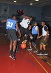 Caught between two 717th Mi Bn players, 802nd FSS guard Charles Burrell lands on the basketball. (U.S. Air Force photo/ Alan Boedeker)