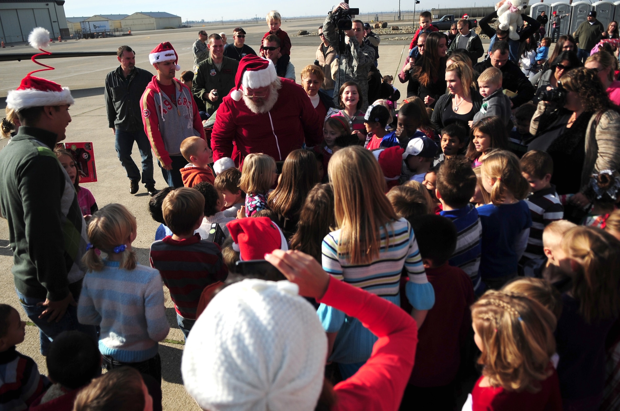 Santa Claus greets Beale youth during the Children's Holiday Party Dec. 10, 2011 at Dock 6, Beale AFB, Calif. The head elf was taxied into dock by an Air Force U-2 Dragon Lady aircraft, sporting nose art portraying Rudolf. (U.S. Air Force photo by Senior Airman Shawn Nickel/Released)