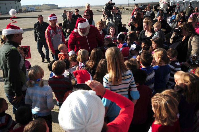 Santa Claus greets Beale youth during the Children's Holiday Party Dec. 10, 2011 at Dock 6, Beale AFB, Calif. The head elf was taxied into dock by an Air Force U-2 Dragon Lady aircraft, sporting nose art portraying Rudolf. (U.S. Air Force photo by Senior Airman Shawn Nickel/Released)