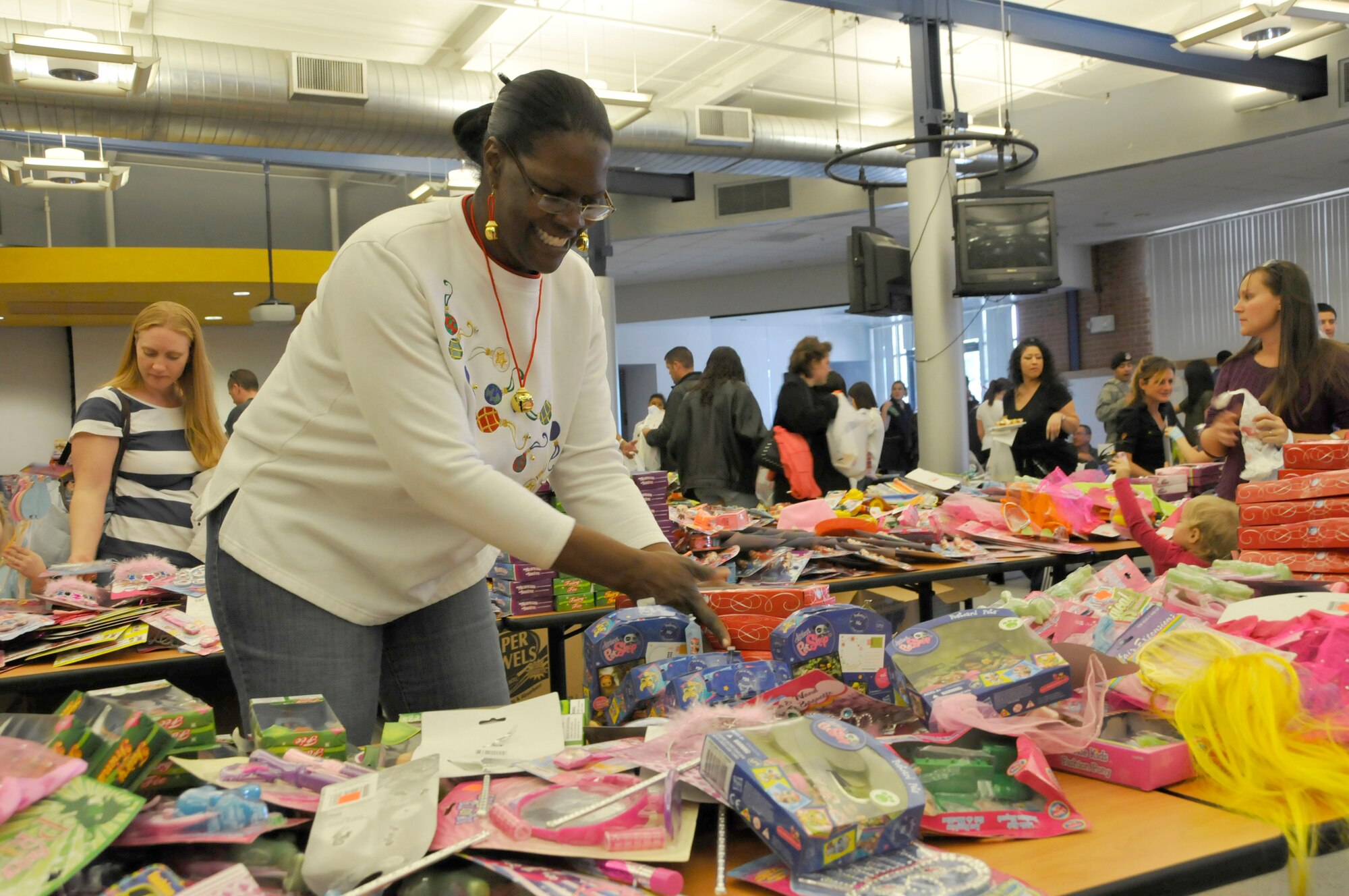 Tech Sgt. Alicia Archie, 162nd Fighter Wing Family Readiness Group volunteer, arranges toys at the Holiday Open House, Dec. 10, in the 162nd Fighter Wing dining facility. (U.S. Air Force photo/Master Sgt. Dave Neve)