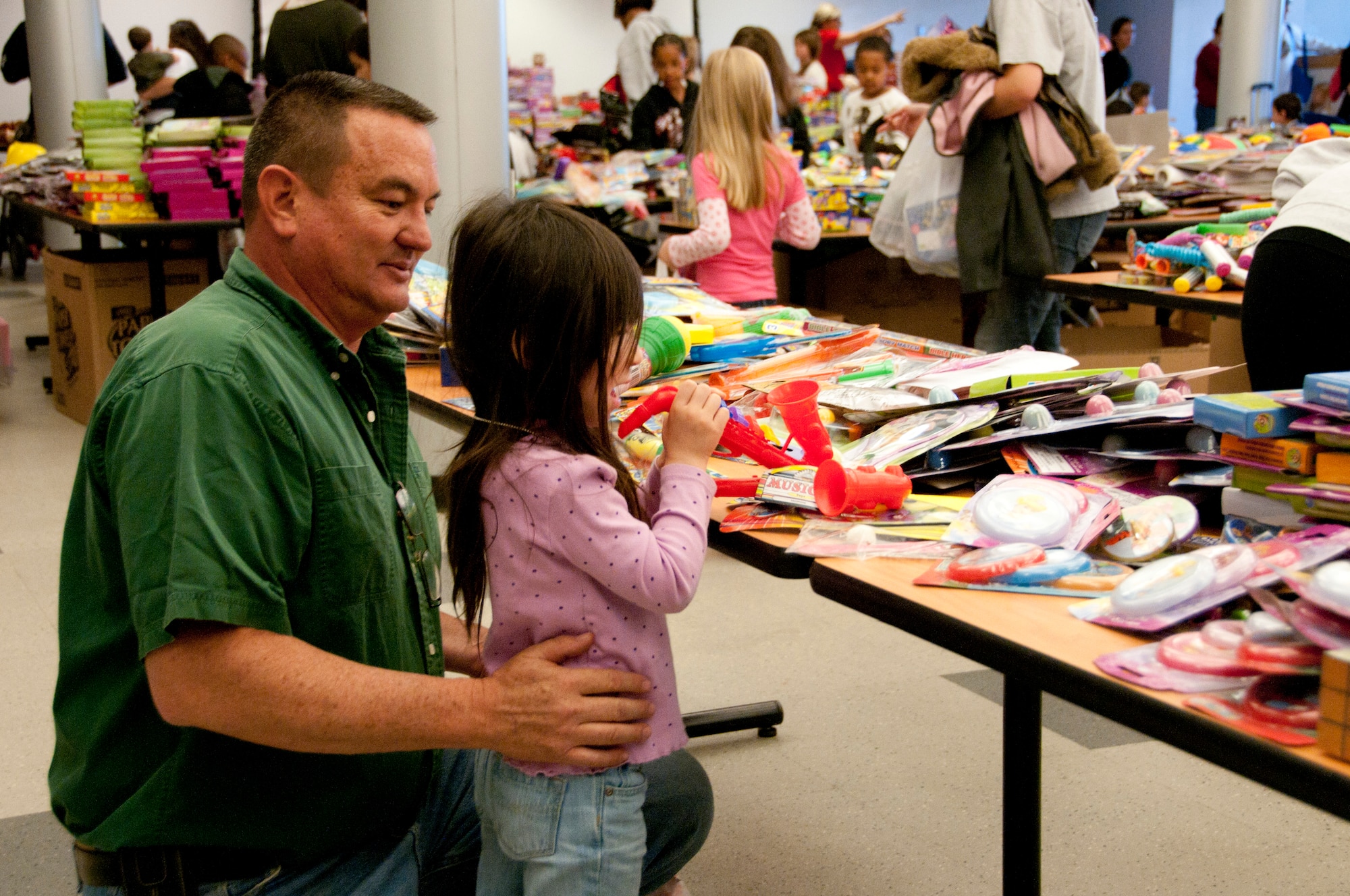 Master Sgt. Dave Morgan, 162nd Maintenance Group, picks out toys with his daughter Alexis, 3, at the Holiday Open House, Dec. 10, in the 162nd Fighter Wing dining facility.  (U.S. Air Force photo/Master Sgt. Dave Neve)
