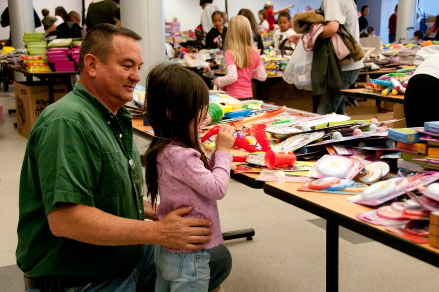 Master Sgt. Dave Morgan, 162nd Maintenance Group, picks out toys with his daughter Alexis, 3, at the Holiday Open House, Dec. 10, in the 162nd Fighter Wing dining facility.  (U.S. Air Force photo/Master Sgt. Dave Neve)