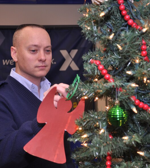 Master Sgt. Phillip Brandley, first sergeant for the 71st Medical Group, hangs a paper angel on the “Angel Tree” in the Exchange, Dec. 11, at Vance Air Force Base, Okla. Each paper angel represents a Team Vance family member in need of a gift for the holiday. The angels provide gender, age, shoe and clothing sizes. (U.S. Air Force photo/ Airman 1st Class Frank John Casciotta)