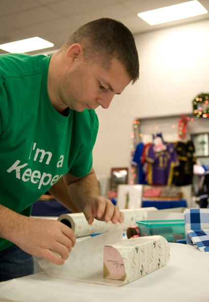 Tech Sgt. Anthony Crawford, 2nd Munitions Squadron, wraps a gift at the Base Exchange on Barksdale Air Force Base, La., Dec. 12. Crawford volunteered to wrap gifts to help fellow Airmen and their families prepare for the holidays. (U.S. Air Force photo/Airman 1st Class Benjamin Gonsier)(RELEASED)