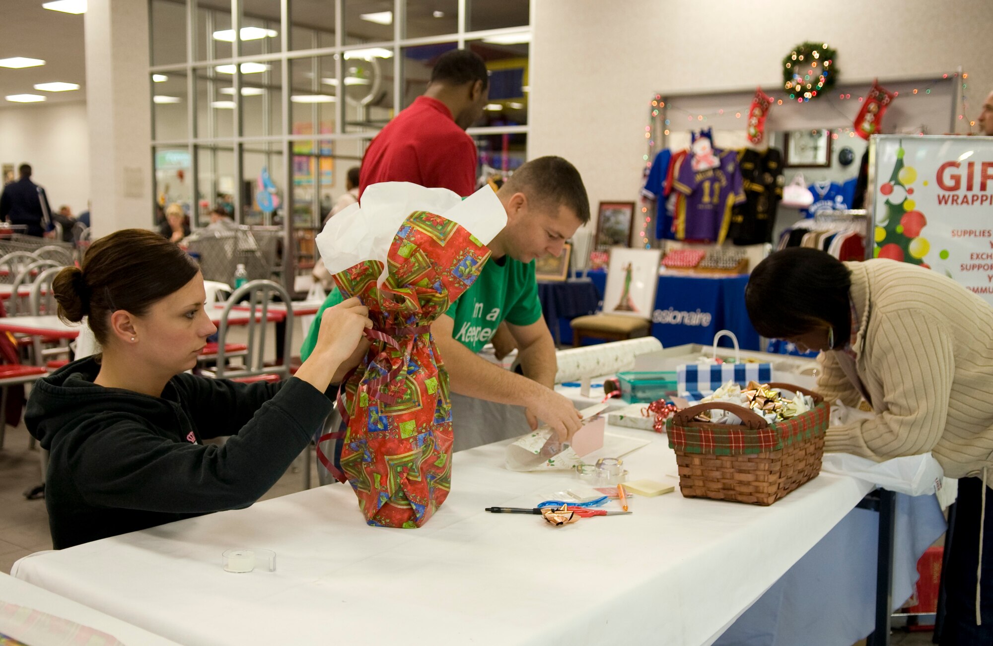 Members of the 2nd Munitions Squadron wrap gifts for members of Team Barksdale at the Base Exchange on Barksdale Air Force Base, La., Dec. 12. Every year, Airmen volunteer to wrap gifts for free to help spread holiday cheer. (U.S. Air Force photo/Airman 1st Class Benjamin Gonsier)(RELEASED)