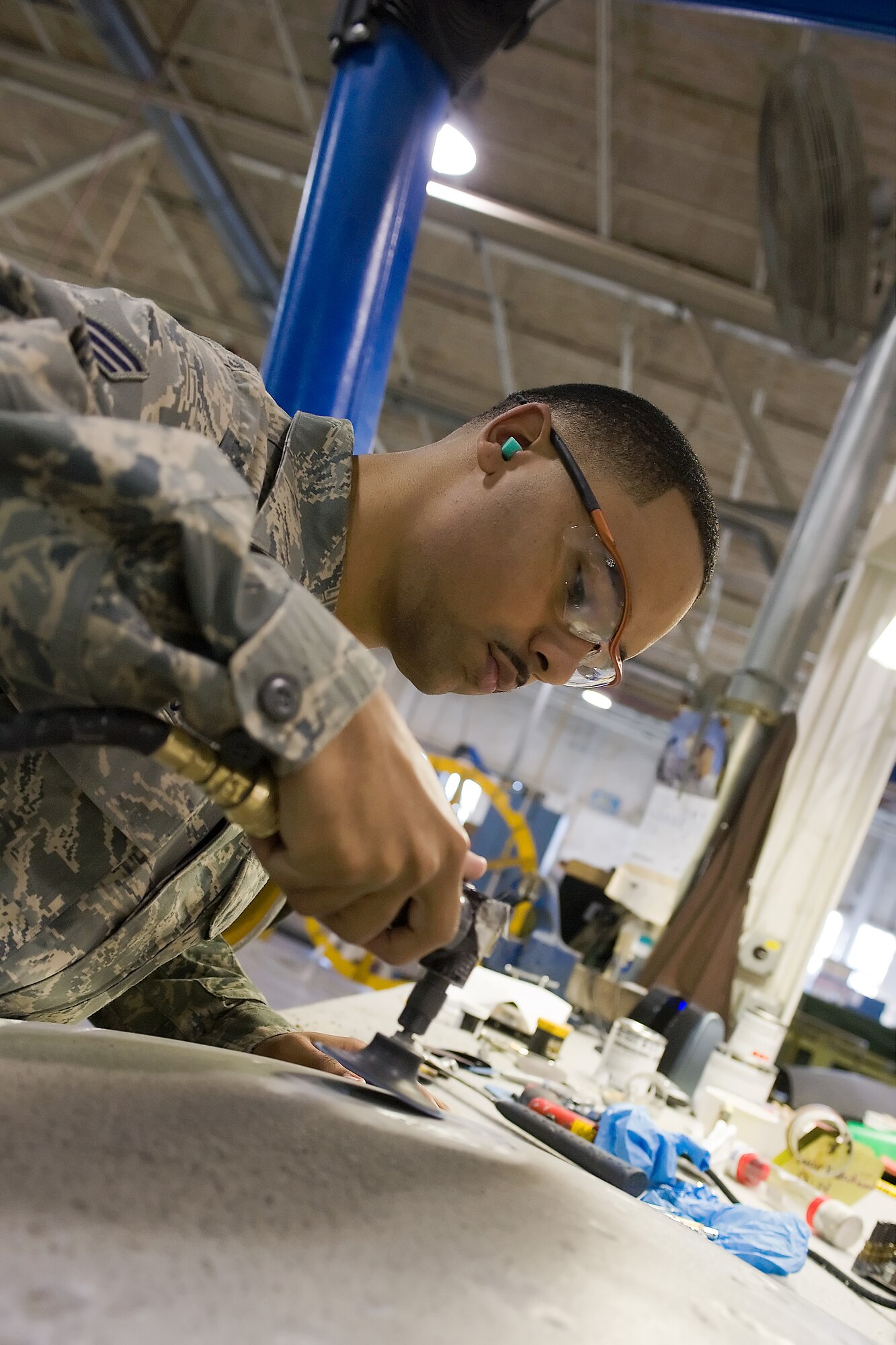 Senior Airman Terrence Davis, aircraft structural maintenance journyman with  the 436th Maintence Squadron, works on sanding an aircraft panel Dec. 13. 2011, at Dover Air Force Base, Del. Senior Airman Davis was selected as the Airman of the Week for oustanding performance while accomplishing his duties. (U.S. Air Force photo/Steve Kotecki)