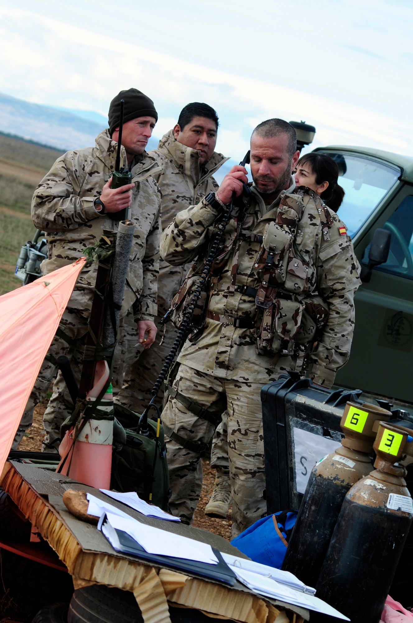 Combat controllers assigned to the Spanish air force communicate with pilots from the 37th Airlift Squadron flying over a designated drop zone during an off-site training in Zaragoza, Spain, Dec. 12, 2011. The OST consisted of a 90 member team and two aircraft, all assembled to enhance interoperability between U.S. and Spanish air forces as well as build partnerships between the two countries. (U.S. Air Force photo by Senior Airman Katherine Holt)