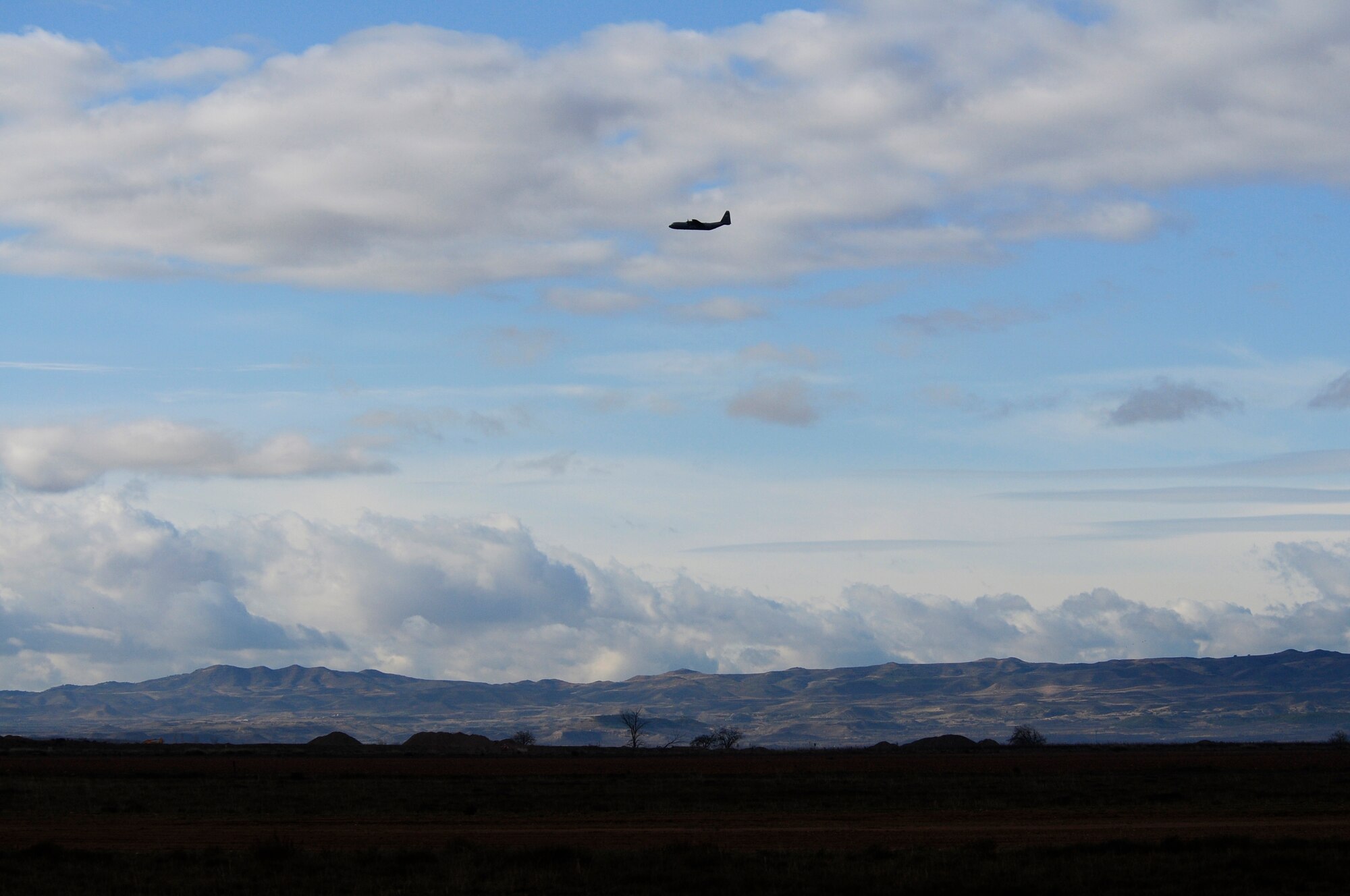 A C-130J Super Hercules flies over a designated drop zone during an off-site training in Zaragoza, Spain, Dec. 12, 2011. The OST consisted of a 90 member team and two aircraft, all assembled to enhance interoperability between U.S. and Spanish air forces as well as build partnerships between the two countries. (U.S. Air Force photo by Senior Airman Katherine Holt)