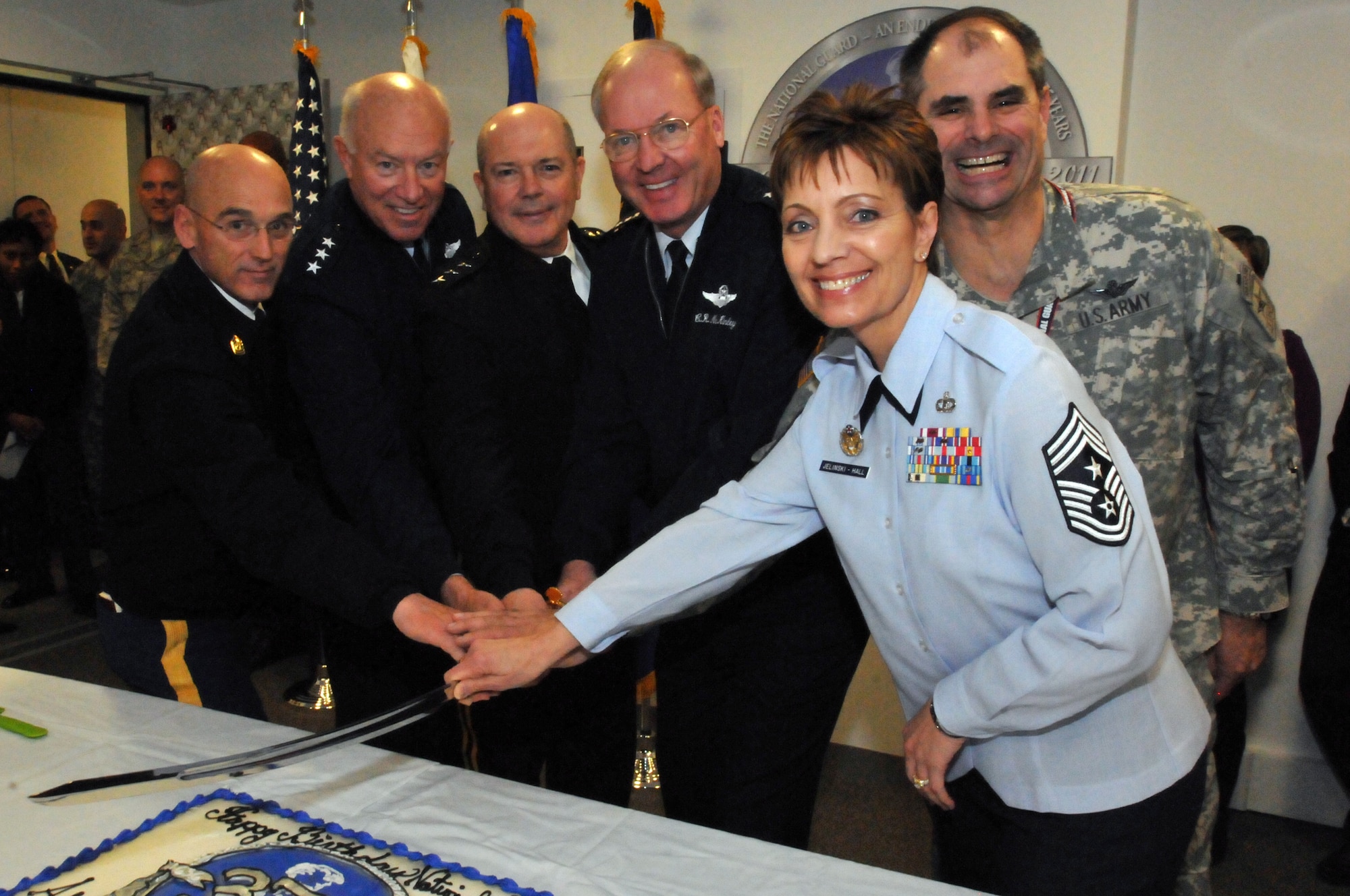 Air Force Gen. Craig McKinley, the chief of the National Guard Bureau (center) prepares to cut into the National Guard's 375th birthday cake with Air Force Chief Master Sgt. Denise Jelinski-Hall, the senior enlisted leader of the National Guard Bureau (front right), Army Chief Warrant Officer 5 Gary Nisker, the Army National Guard command chief warrant officer (back right), Army Lt. Gen. William E. Ingram Jr., the director of the Army National Guard (center left), Air Force Lt. Gen. Harry Wyatt, the director of the Air National Guard (left) and Army Command Sgt. Maj. Richard Burch, the Army National Guard command sergeant major (far left), on Dec. 13, 2011 in Arlington, Va. (Air National Guard photo by Tech. Sgt. John Orrell) (Released)