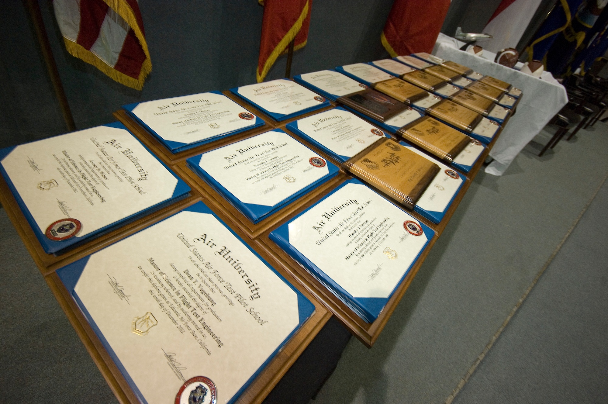 Twenty-three Master of Science in Flight Test Engineering degrees rest on a table before they’re presented to each U.S. Air Force Test Pilot School graduate in a graduation ceremony, Dec. 10. Class 11A, comprised of officers from the USAF, U.S. Navy, French Air Force and the Royal Canadian Air Force, completed nearly a year-long course where they learned to develop, test and evaluate the newest aircraft and weapons systems. (Air Force photo by Rob Densmore)