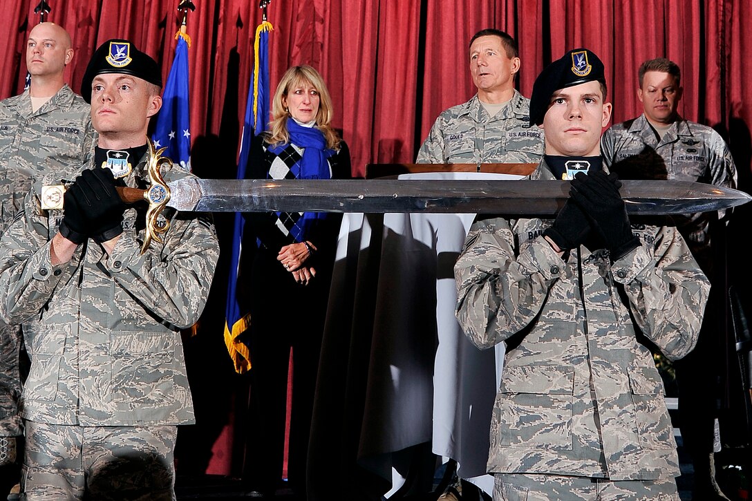 Lt. Gen. Mike Gould (back center) thanks the Air Force Academy's enlisted Airmen for offering him induction into the Order of the Sword during a ceremony at the Falcon Club Dec. 13, 2011. Senior Airman William Magill and Airman 1st Class Joshua Bailey (foreground) held the ceremonial sword. Gould is the Academy superintendent. Magill and Bailey are assigned to the 10th Security Forces Squadron. Also pictured are, from left: 10th Air Base Wing Command Chief Master Sgt. David Staton, Paula Gould and Academy Command Chief Master Sgt. Todd Salzman. (U.S. Air Force photo/Elizabeth Andrews)