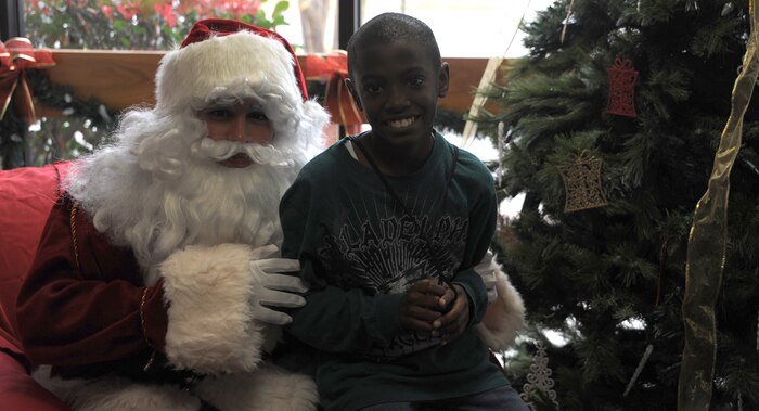 Retired Master Sgt. Theresa Green's son, Quinton Dorsey, sits on Santa Claus' lap at the Youth Holiday Party at Joint Base Charleston - Air Base Dec. 10. The Youth Center put together a Holiday Party for kids of all ages, and had fun stations including: "VanDoren" the Magician, a bounce house, dart throwing, mini-golf, face painting, free food and a surprise appearance from Santa Claus. (U.S. Air Force photo/Airmen 1st Class Ashlee Galloway)