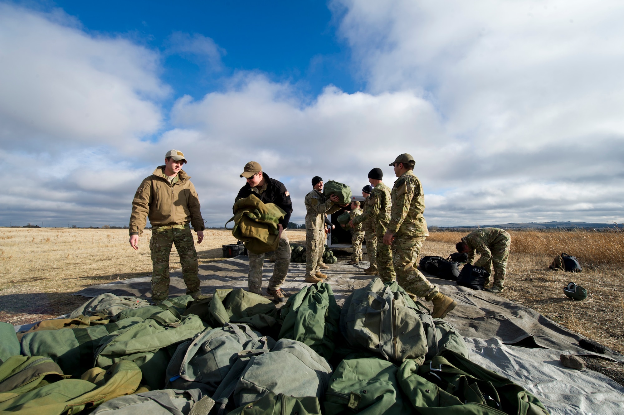 Members of the Survival, Evasion, Resistance and Escape School unload their parachute equipment at their training field on Fairchild Nov. 28. Being a SERE instructor is a specialized career field in the Air Force. They prepare DOD personnel to return from isolated events with honor. (U.S. Air Force photo/Airman 1st Class Taylor Curry