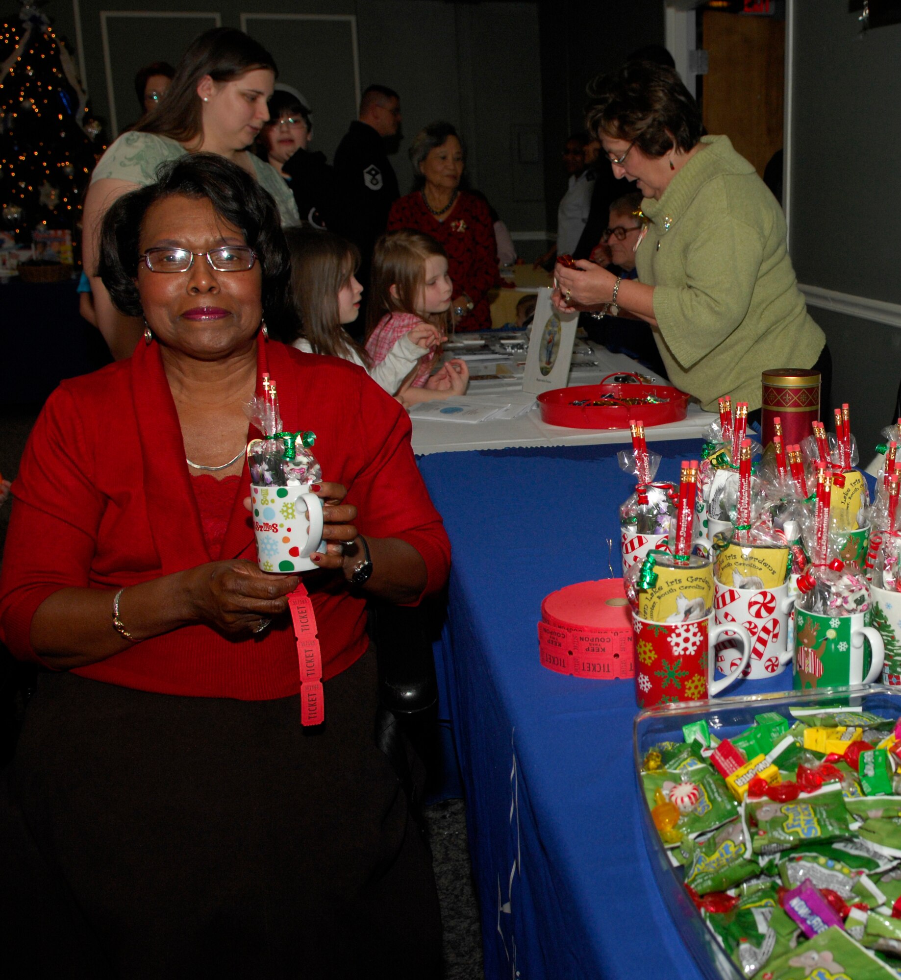 Ione Dwyer, Sumter City Council Ward Two, poses for a photo while volunteering to give out tickets and gift mugs at the deployed families' dinner Dec. 12, 2011, Shaw Air Force Base, S.C. The dinner was held at the Carolina Skies Club and offered a free family dinner, Christmas gifts and goodies to all children of all ages.  (U.S. Air Force photo by Airman 1st Class Ashley L. Gardner/ Released)
