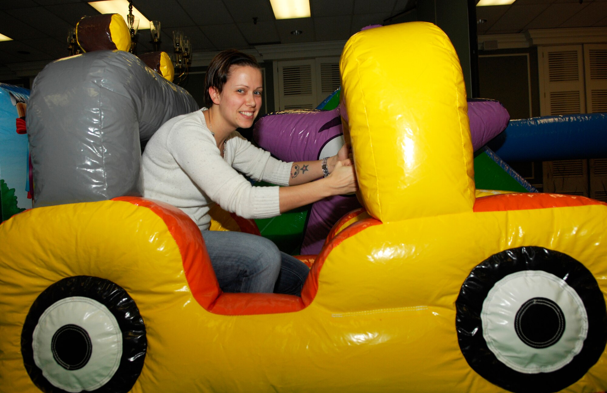 U.S. Air Force Tech. Sgt. April Richer, 20th Operations Support Squadron, sits in a bouncy house at the deployed families' dinner Dec. 12, 2011, Shaw Air Force Base, S.C. The dinner was held at the Carolina Skies Club and offered a free family dinner,  Christmas gifts and goodies to the children.  (U.S. Air Force photo by Airman 1st Class Ashley L. Gardner/ Released)
