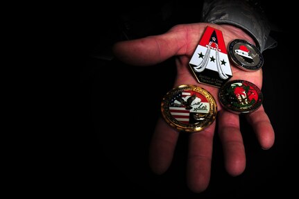 Master Sgt. Scott Kapanke holds some of the coins he received during his 365-day deployment with the Coalition Air Force transition team. Kapanke was diagnosed with stage four cancer in 1995 and was medically retired while he underwent treatment. He beat the cancer and was then medically cleared to re-enlist in the Air Force in 1997.  Since his return to active duty, he has taken a special duty assignment with the U.S.A.F. Thunderbirds and deployed for 365 days with the Coalition Air Force transition team to Southwest Asia to train the Iraqi Air Force on C-130 aircraft maintenance. Kapanke is with the 437th Aircraft Maintenance Squadron. (U.S. Air Force photo/ Staff Sgt.
Nicole Mickle)  
