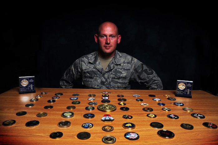 Master Sgt. Scott Kapanke displays some of the coins he has received throughout his Air Force career. Kapanke was diagnosed with stage four cancer in 1995 and was medically retired while he underwent treatment. He beat the cancer and was then medically cleared to re-enlist in the Air Force in 1997.  Since his return to active duty, he has taken a special duty assignment with the U.S.A.F. Thunderbirds and deployed for 365 days with the Coalition Air Force transition team to Southwest Asia to train the Iraqi Air Force on C-130 aircraft maintenance. Kapanke is with the 437th Aircraft Maintenance Squadron.  (U.S. Air Force photo/ Staff Sgt. Nicole Mickle)  