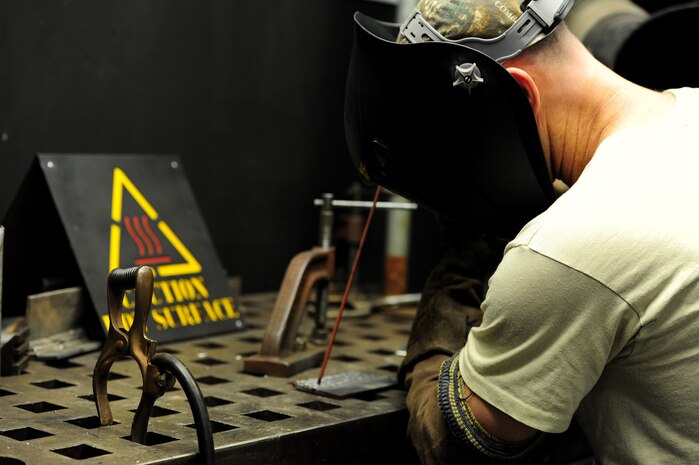 A prisoner works in the metal shop inside the Naval Consolidated Brig Charleston at Joint Base Charleston - Air Base Sept. 20. Prisoners have the opportunity to participate in a variety of certification and trade programs including automotive repair, wood-working, metal fabrication and the sail-loft shop where they learn embroidery skills. These programs serve as  rehabilitation tools for the prisoners. (U.S. Air Force photo/ Staff Sgt. Nicole Mickle) 