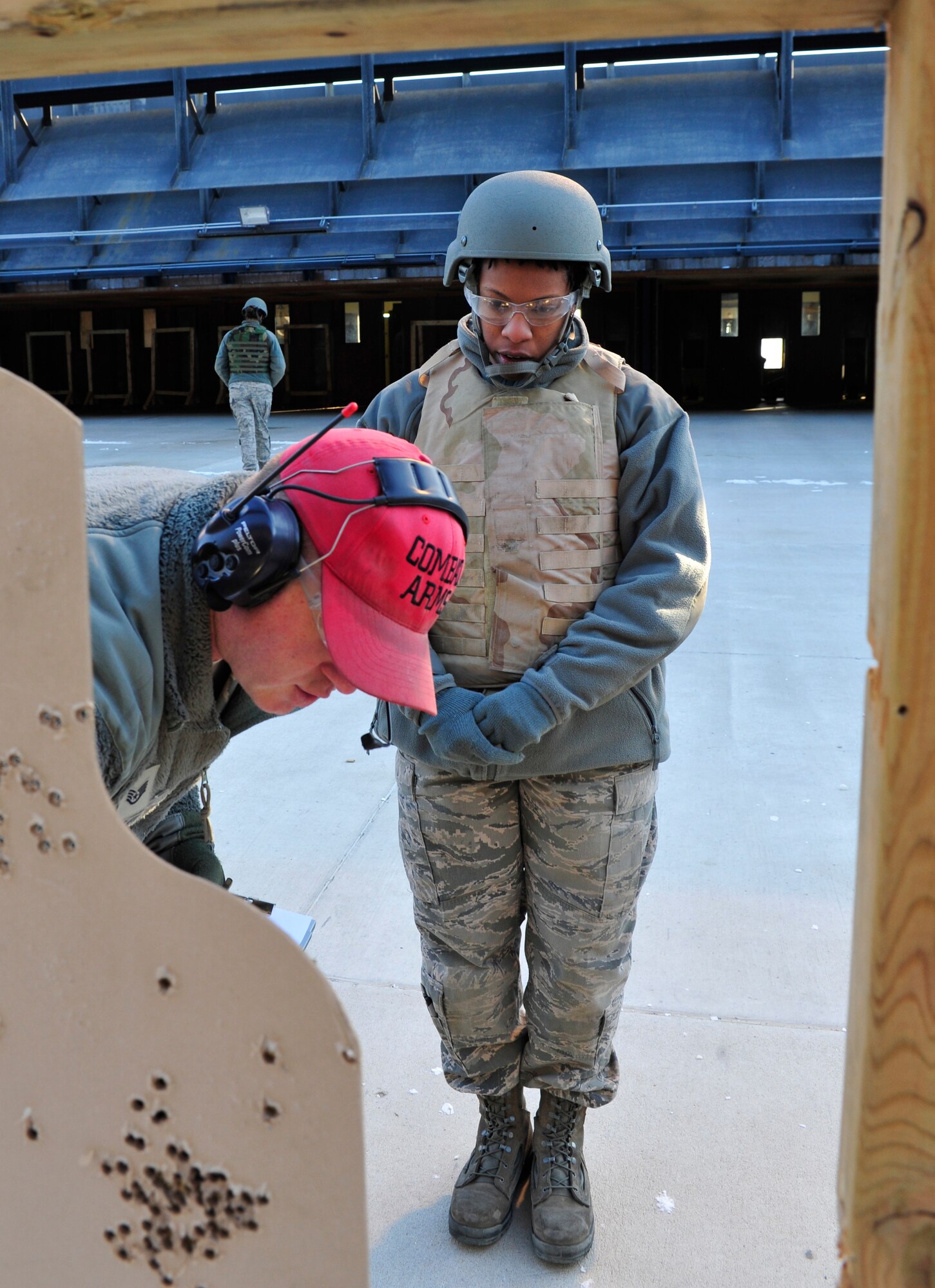 MINOT AIR FORCE BASE, N.D. – Staff Sgt. Joseph Haller, 5th Security Forces Squadron combat arms training and maintenance instructor, trains Airman 1st Class Daniela Toney, 5th Logistics Readiness Squadron transportation management, on qualifying firing procedures here, Dec. 8. CATM instructors are security forces personnel who train military members on weapon use. They also maintain and repair weapons in the security forces inventory. (U.S. Air Force photo/Senior Airman Desiree Esposito) 
