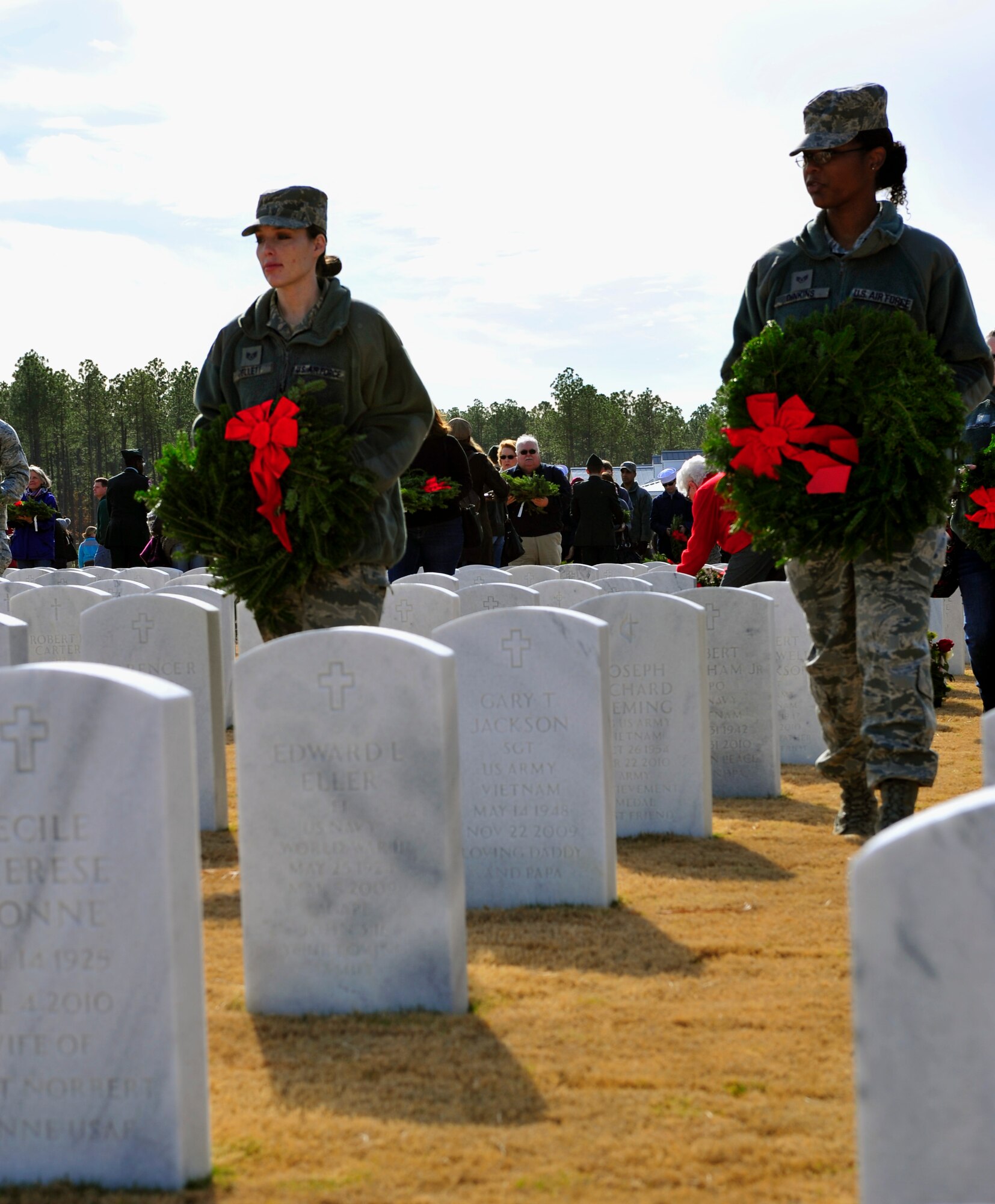 U.S. Air Force Staff Sgts. Tonya Collett and Latoria Dinkins, 20th Dental Squadron, walk to gravestones to lay wreaths on them during the Wreaths Across America ceremony at Fort Jackson National Cemetery, Columbia, S.C., Dec. 10, 2011. Wreaths Across America occurs the second Saturday of December every year. People gather to lay holiday wreaths on the gravestones at national military cemeteries. (U.S. Air Force photo/Senior Airman Daniel Phelps/Released)