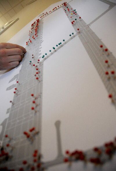 Pins are placed on a map of the flightline to indicate areas requiring maintenance Dec. 12 on Barksdale Air Force Base, La. More than 10,000 feet of the flightline will close Dec. 17 until the beginning of 2012. Airmen from the 2nd Operations Support Squadron airfield management flight and contractors will remove rubber build-up, foreign object debris, and pave cracks on the airfield. (U.S. Air Force photo/Senior Airman Amber Ashcraft)(RELEASED)