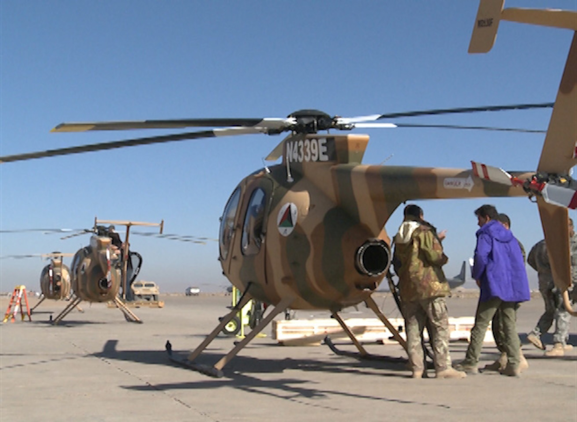 Maintenance personnel fuel MD 530F helicopters prior to aceeptance flights at Shindand, Afghanistan, Dec. 7(Air Force photo/Staff Sgt. isaac Garden)