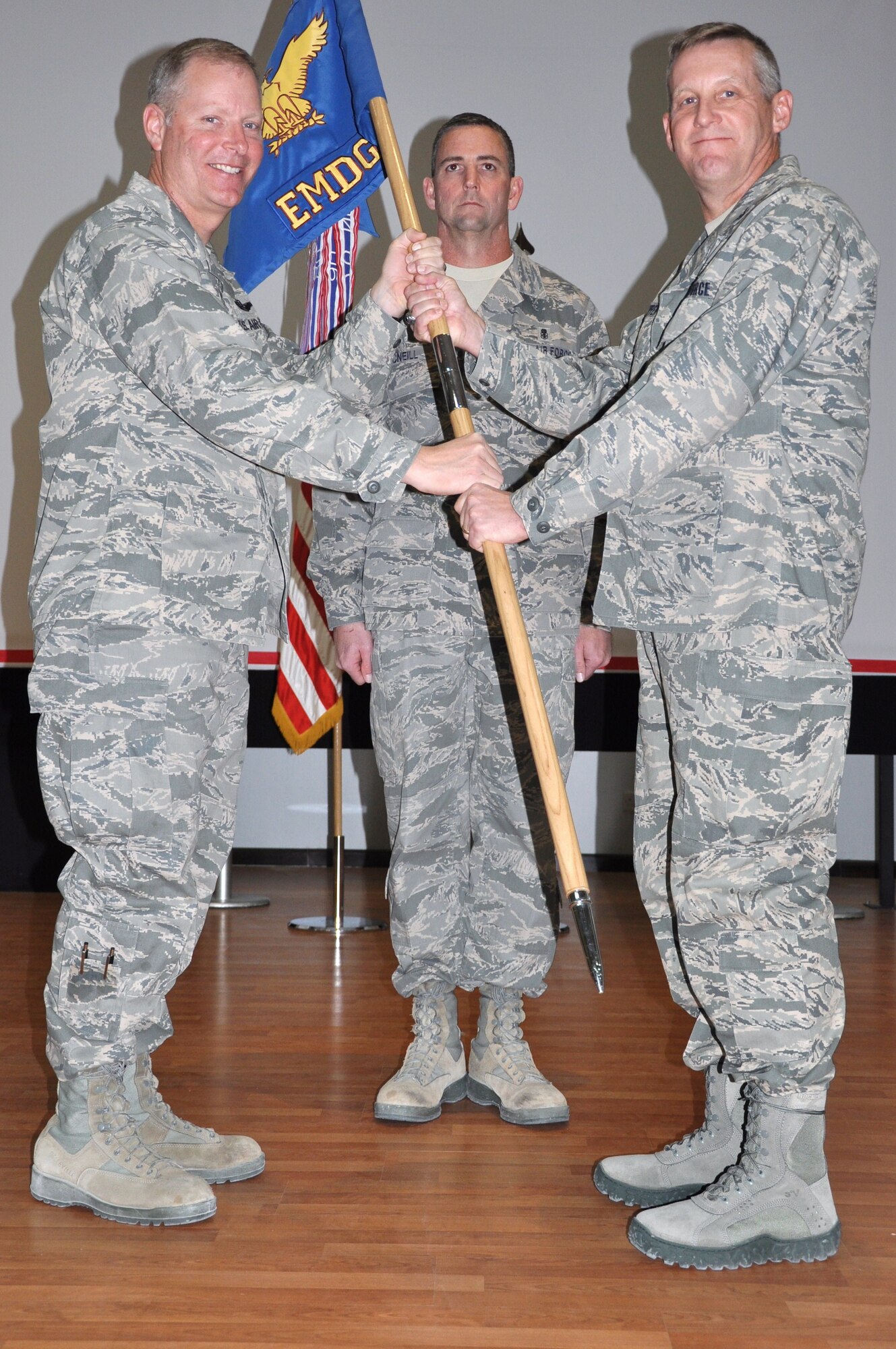 Col. Michael Zick, 386th Air Expeditionary Wing commander, left, passes the 386th Expeditionary Medical Group guide-on to Col. Mark Koppen during a change of command ceremony Dec 12 at an undisclosed location in Southwest Asia. Colonel Koppen assumed command of the 386th MDG from Col. Craig Rice. (U.S. Air Force photo by Senior Airman Rachelle Elsea)
