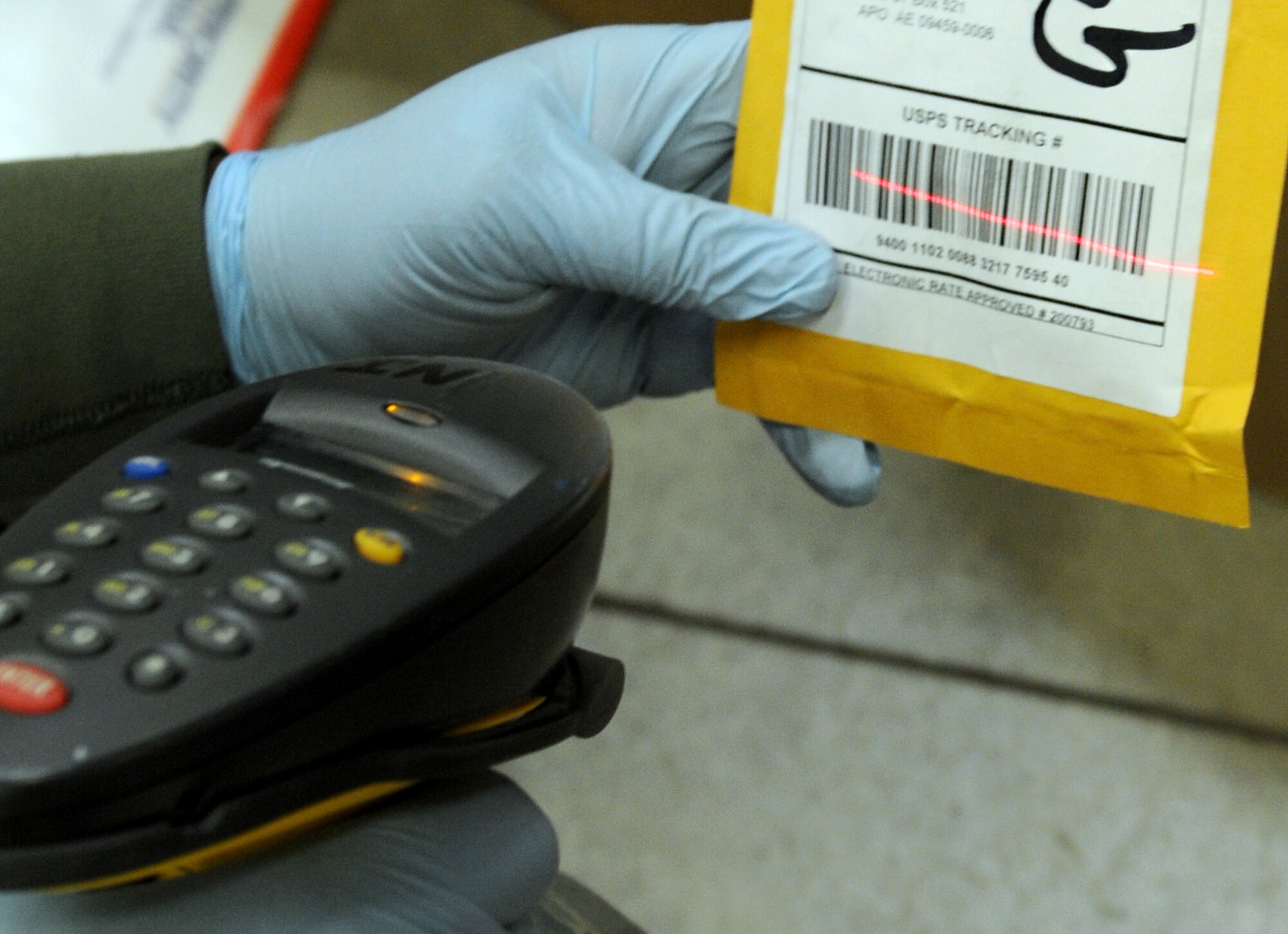 RAF MILDENHALL, England -- Senior Airman Jarvis Cobb, 100th Communications Squadron postal worker, uses a barcode scanner to scan an inbound package at the post office here Dec. 9, 2011. Scanned items are loaded into the United States Postal Service database which allows customers to track their parcels. (U.S. Air Force photo by Staff Sgt. Tabitha M. Lee)