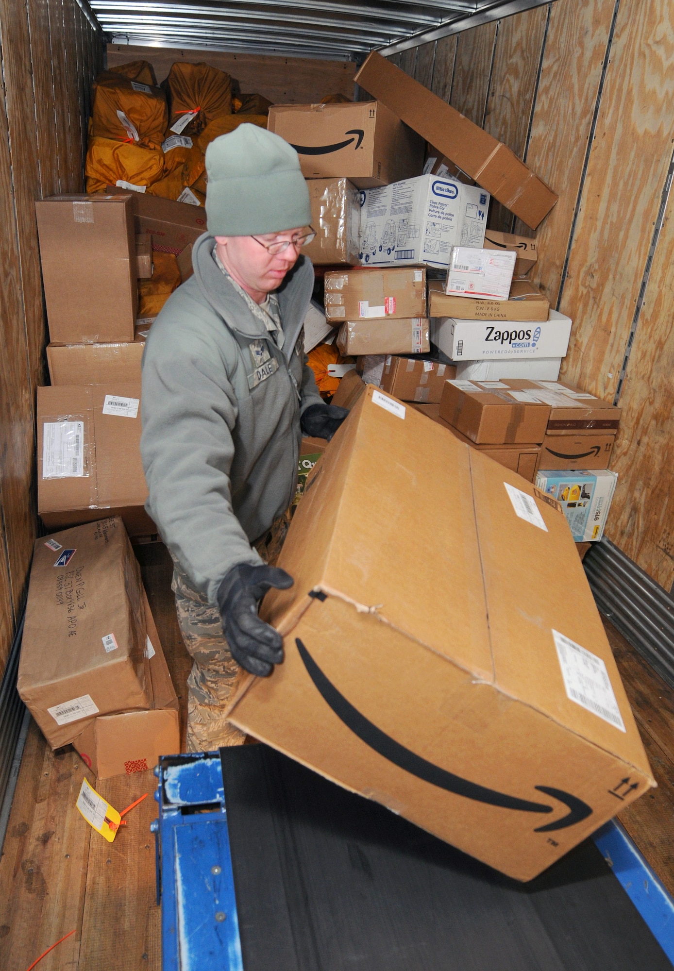 RAF MILDENHALL, England -- Senior Airman Christopher Dale, 100th Communications Squadron postal worker, unloads a delivery truck at the post office here Dec. 9, 2011. During the holiday season, the post office receives double the amount of packages than normal. (U.S. Air Force photo by Staff Sgt. Tabitha M. Lee)