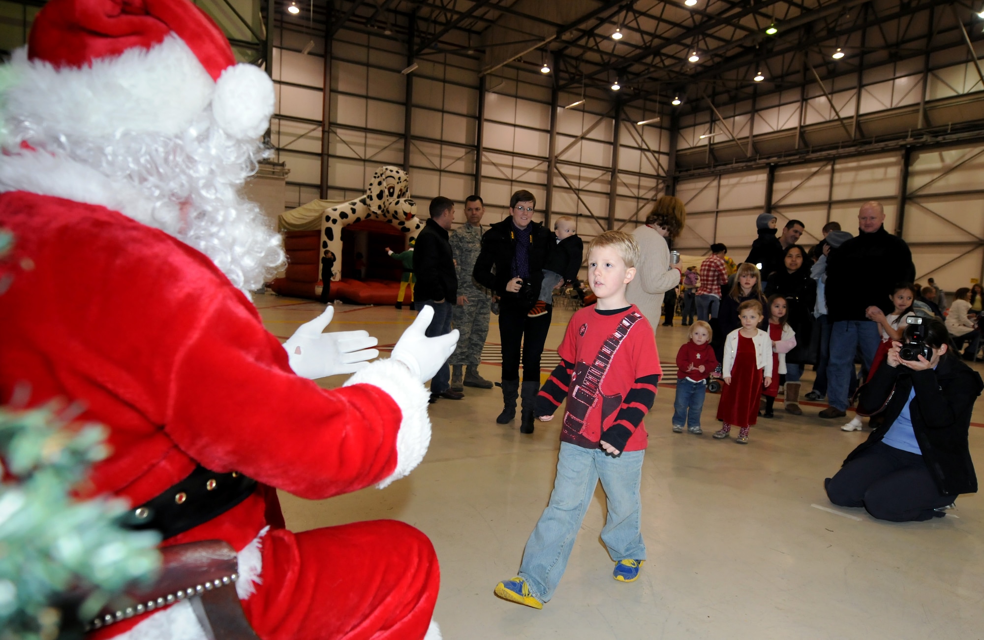 RAF MILDENHALL, England -- Dewey Holley, son of Staff Sgt. Cara Holley, 100th Operations Support Squadron aircrew flight equipment, takes his turn to sit on Santa Claus’ knee in Hanger 803 here Dec. 10, 2011. Santa, his elves and Rudolph arrived in a KC-135 Statotanker to visit with children from RAF Mildenhall during a children’s holiday party. (U.S. Air Force photo/Staff Sgt. Tabitha M. Lee)