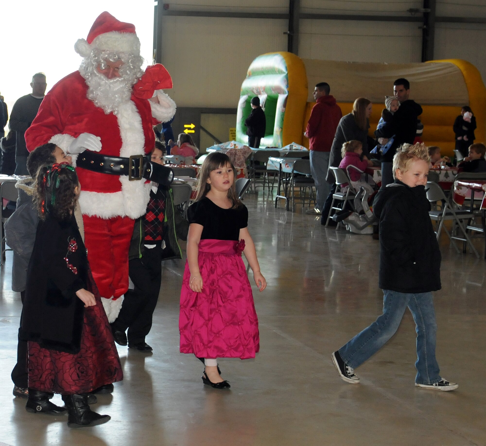 RAF MILDENHALL, England -- RAF Mildenhall children escort Santa Claus to his seat here Dec. 10, 2011 in Hanger 803. Santa, his elves and Rudolph arrived in a KC-135 Statotanker to visit with children from the base during a children’s holiday party. (U.S. Air Force photo/Staff Sgt. Tabitha M. Lee)